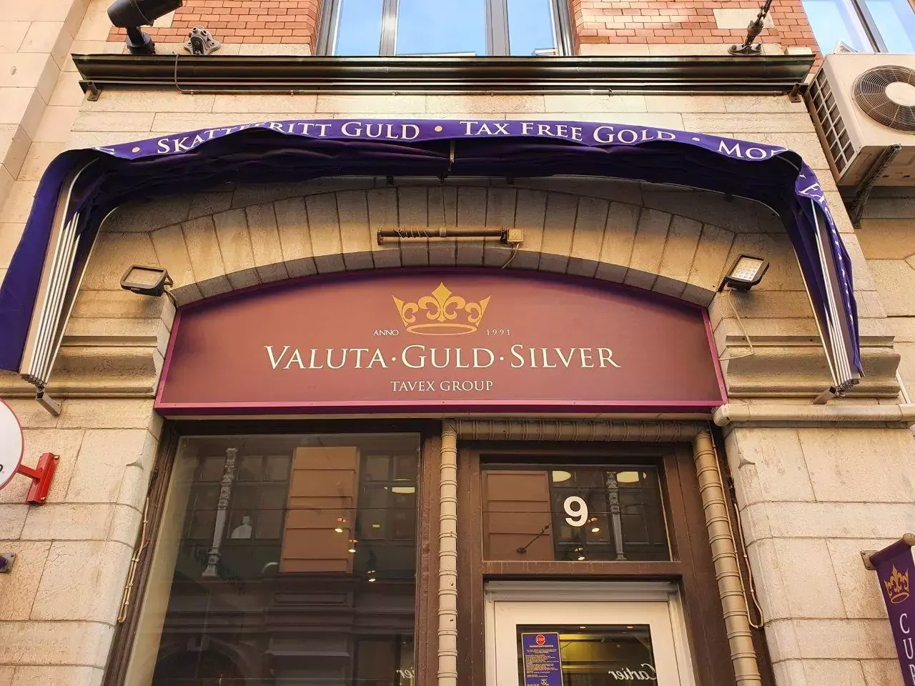 Belyst butiksskylt över entré