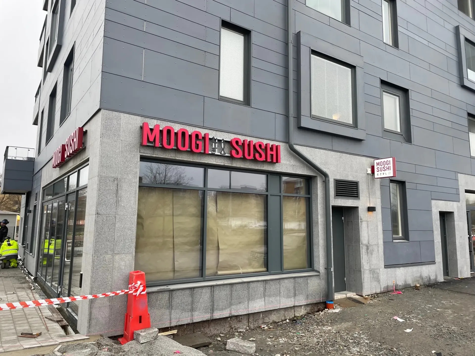 Profilskylt för Moogi Sushi i kvällsbelysning