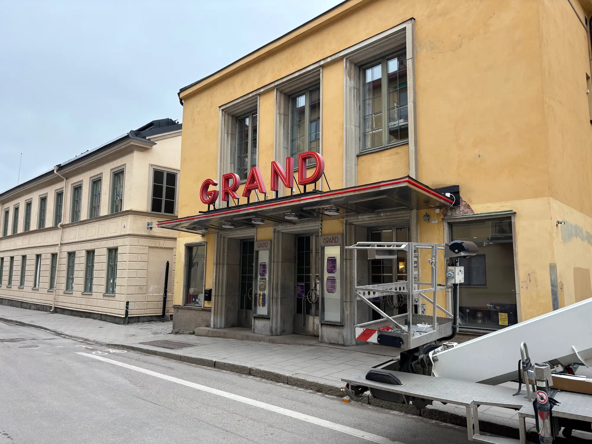 Röd neonskylt med texten Grand ovanför biografens entré