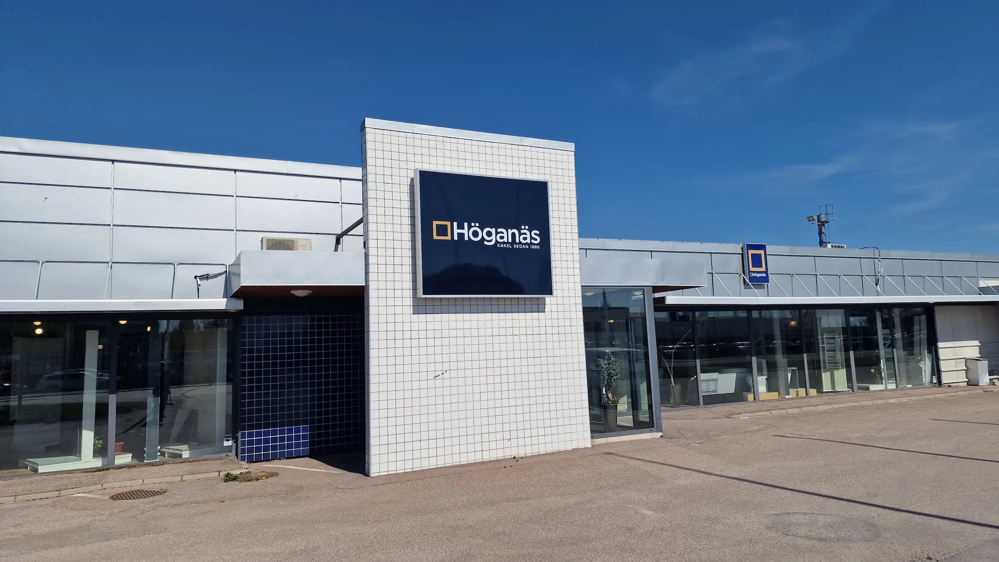 Stor dukskylt för Höganäs monterad på fasad