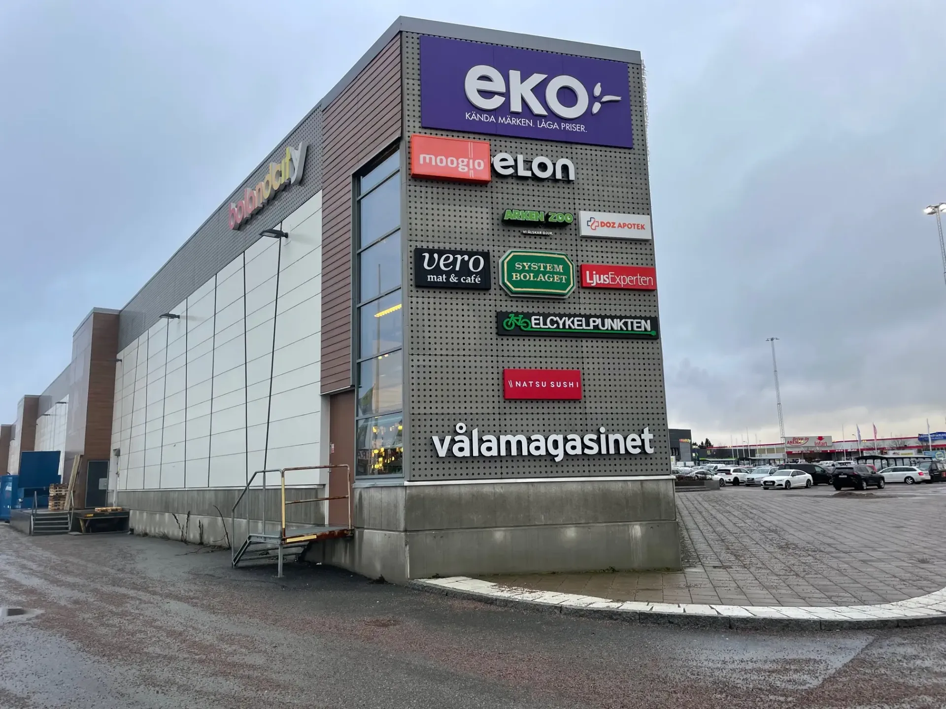 Samling av ljuslådor och belysta skyltar i olika utföranden på en köpcentrumfasad
