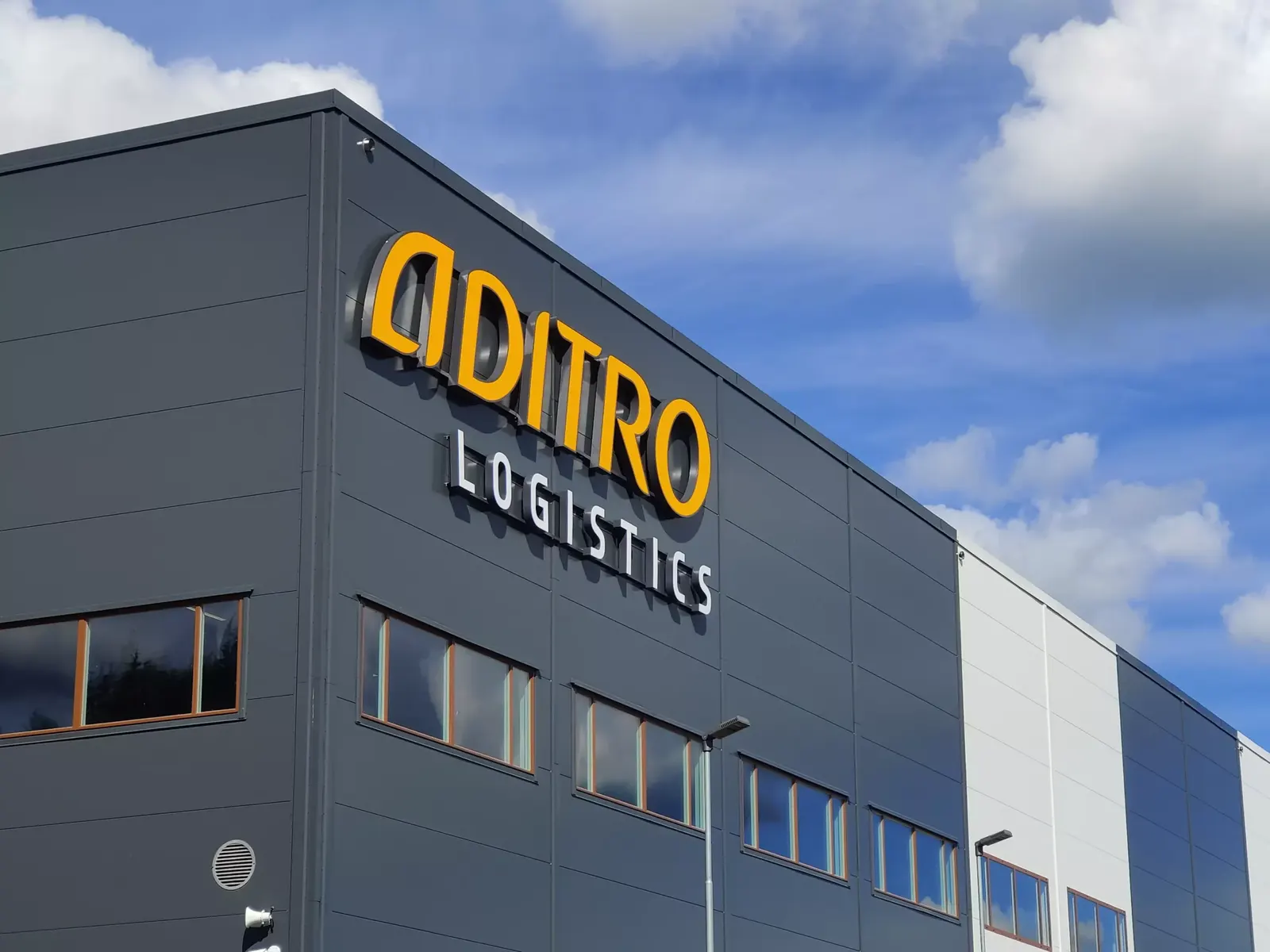 Belyst fasadskylt på Aditro Logistics anläggning i Skillingaryd